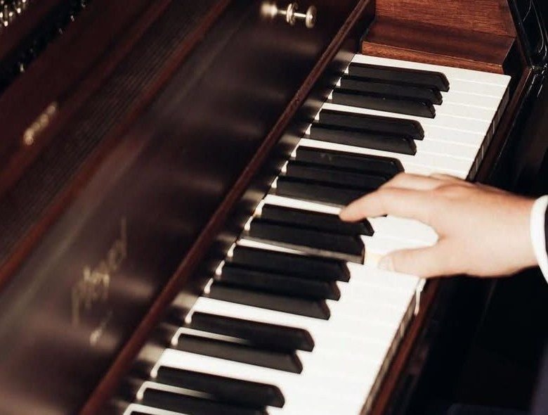 Mano sobre las teclas de un piano de madera oscura